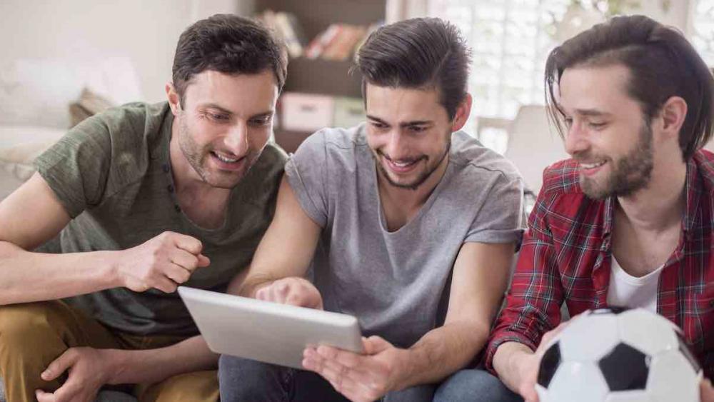 Hombres viendo un video en una tableta Hombres viendo un video en una tableta