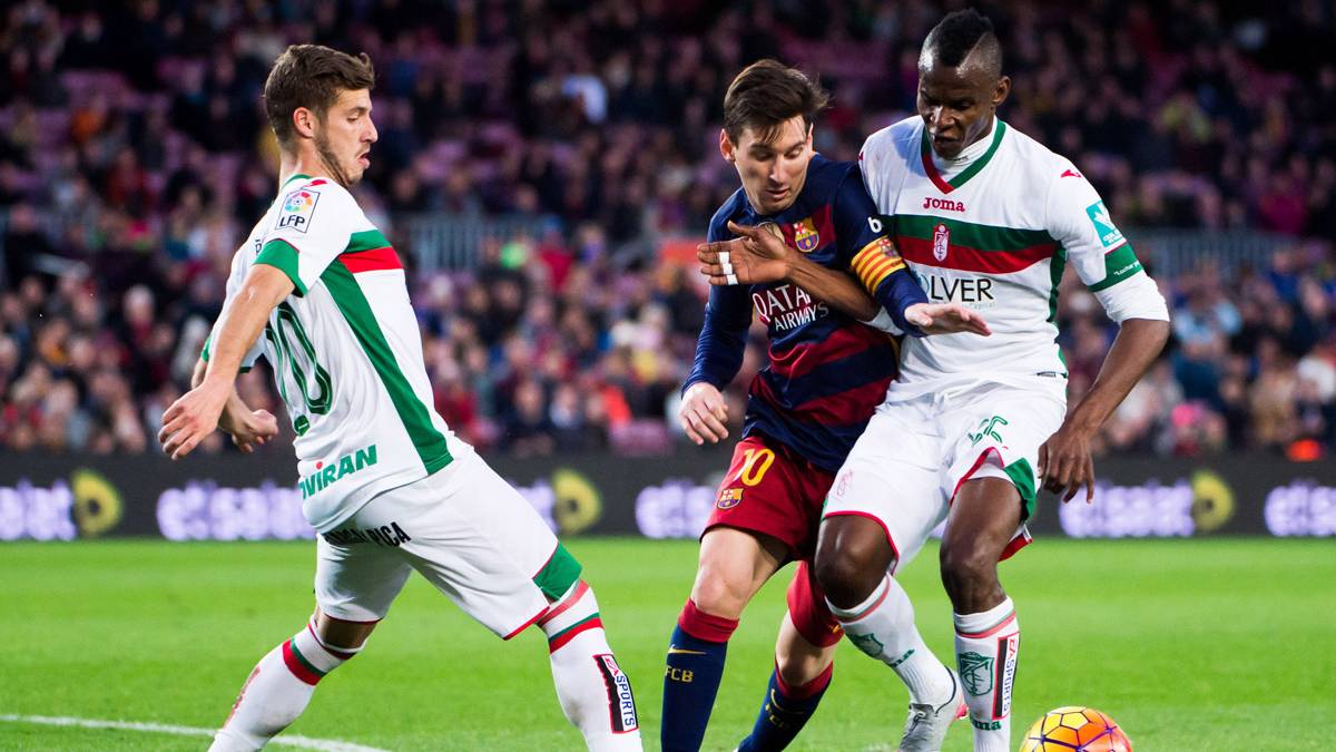 Leo Messi, intentando marcharse de dos rivales contra el Granada