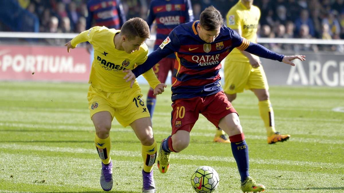 Denis Suárez, luchando por un balón con Leo Messi