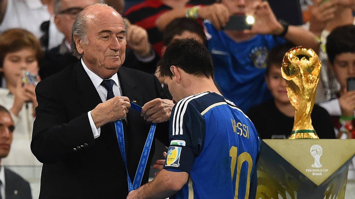 El ex presidente de la FIFA, Joseph Blatter, colocando la medalla de plata a Messi