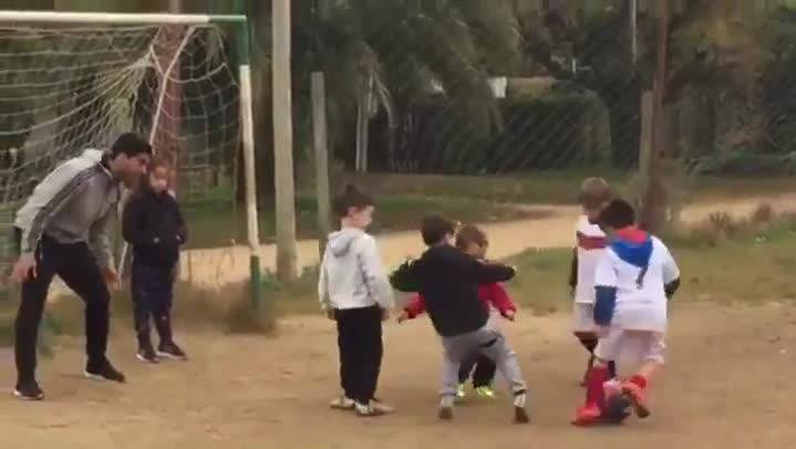 Luis Suárez playing to football with several boys and his son Benja