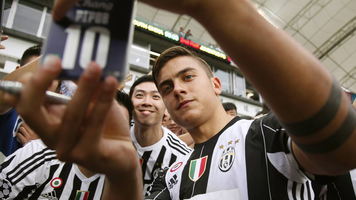 Paulo Dybala, fotografiándose con un fan de la Juventus