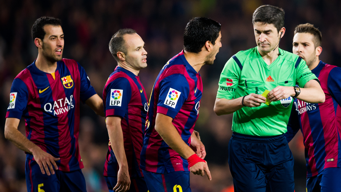 Undiano Mallenco, a punto de mostrar una tarjeta a un jugador del Barça