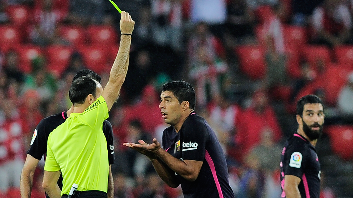 Mateu Lahoz, mostrando una tarjeta a Luis Suárez por protestar