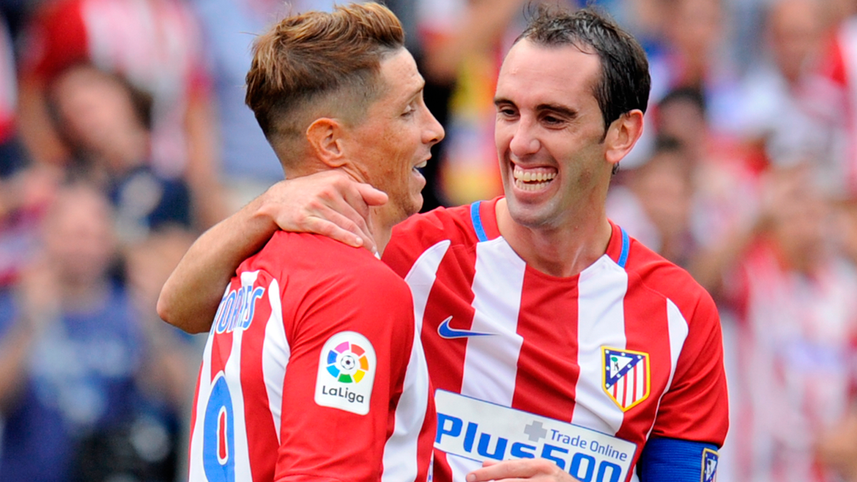 Godín, felicitando a Fernando Torres por un gol al Sporting de Gijón
