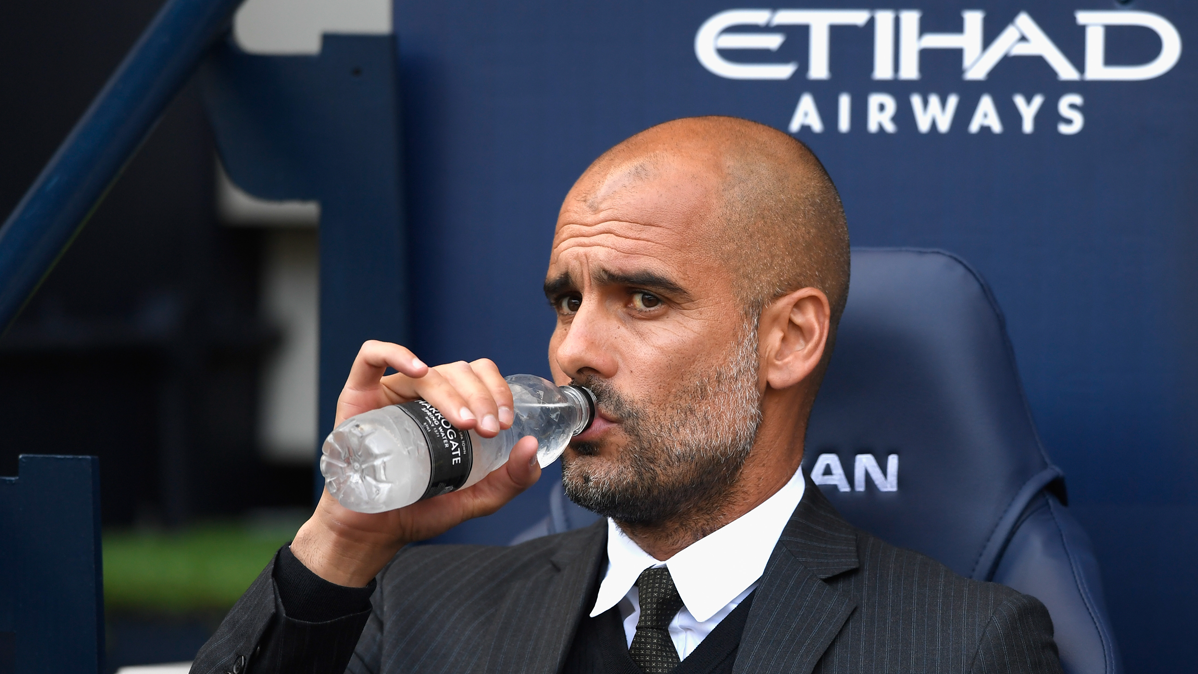 Pep Guardiola, bebiendo agua en el banquillo del Manchester City