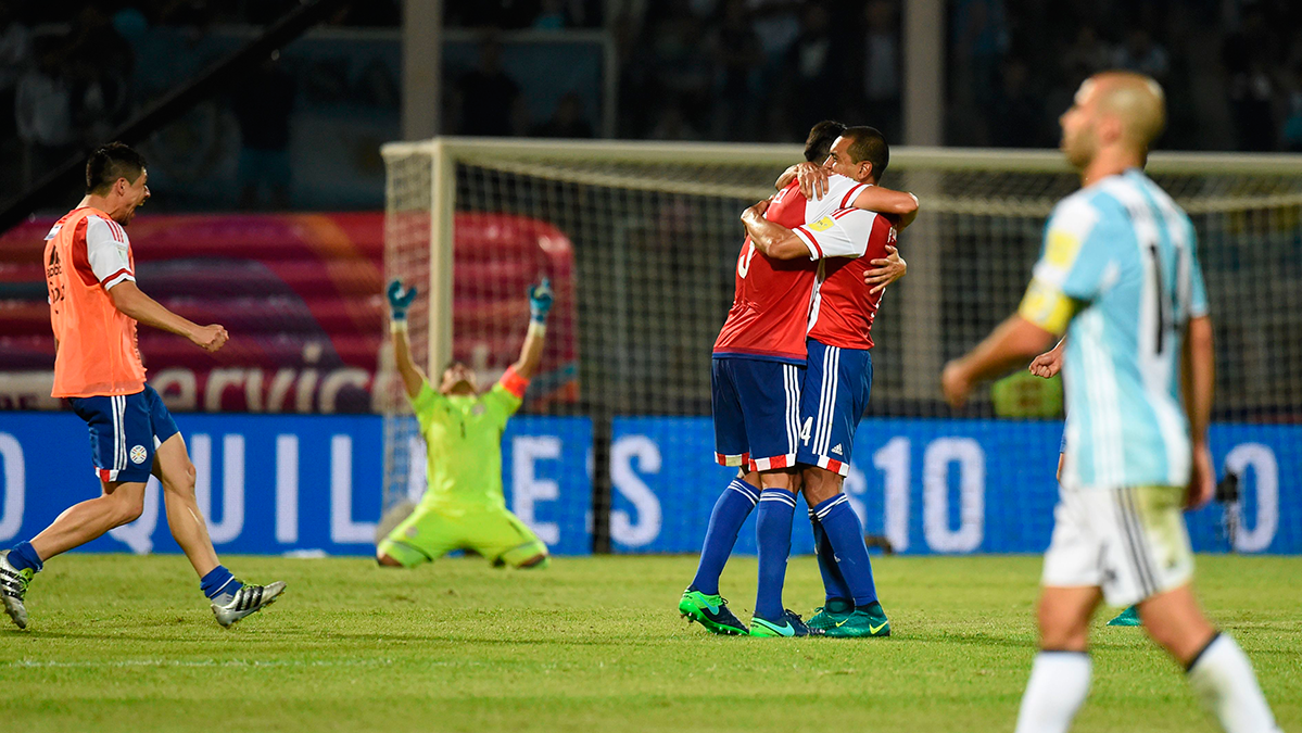 Javier Mascherano con los paraguayos, de fondo, celebrando la victoria