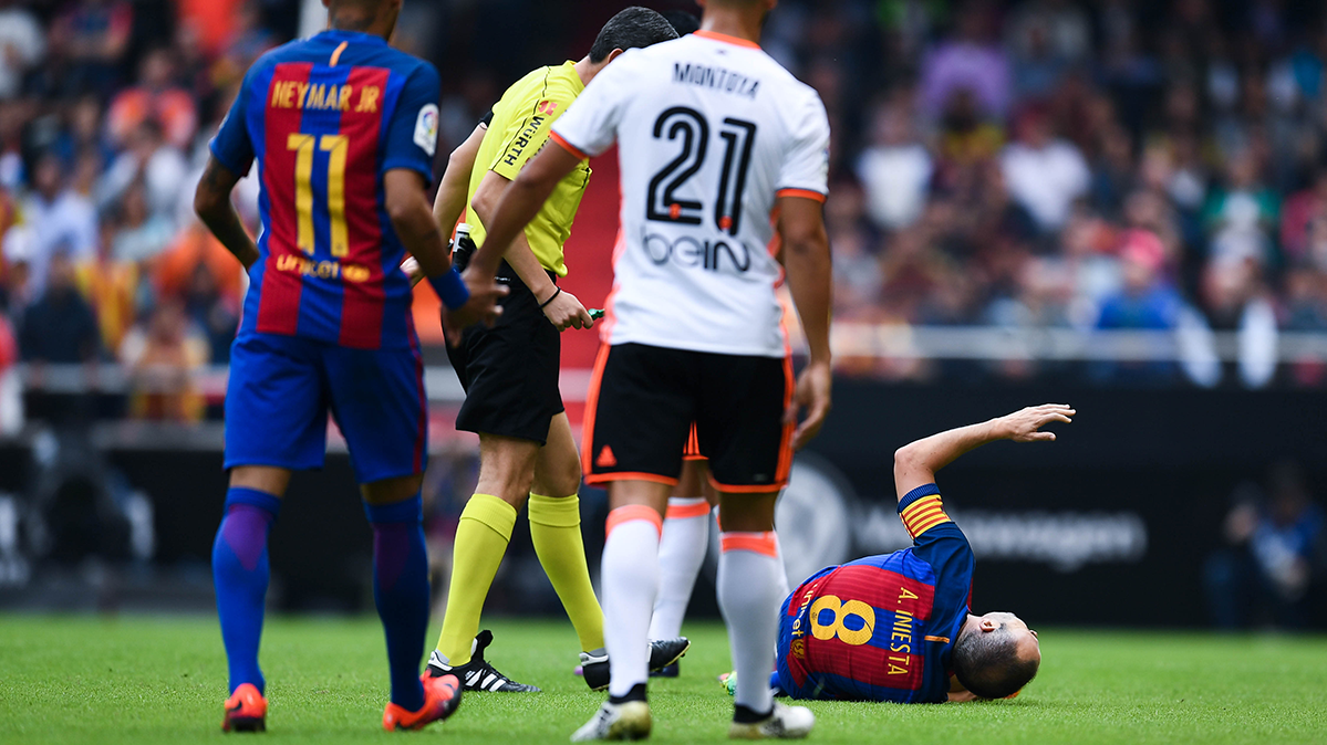 Undiano Mallenco atiende al lesionado Andrés Iniesta durante el Valencia-Barça
