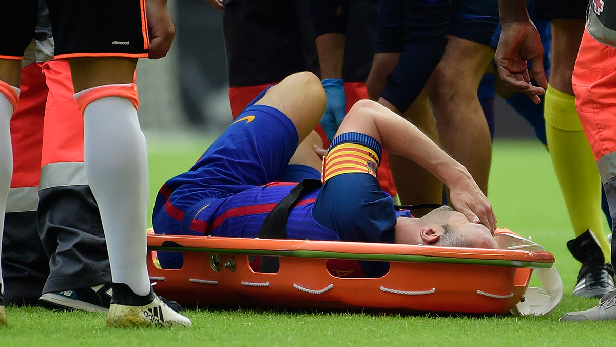 Andrés Iniesta dolorido y retirándose en camilla en el Valencia-Barça