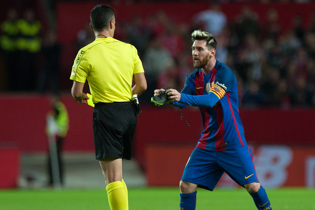 Leo Messi enseñándole la bota rota por un defensor antes de ser amonestado