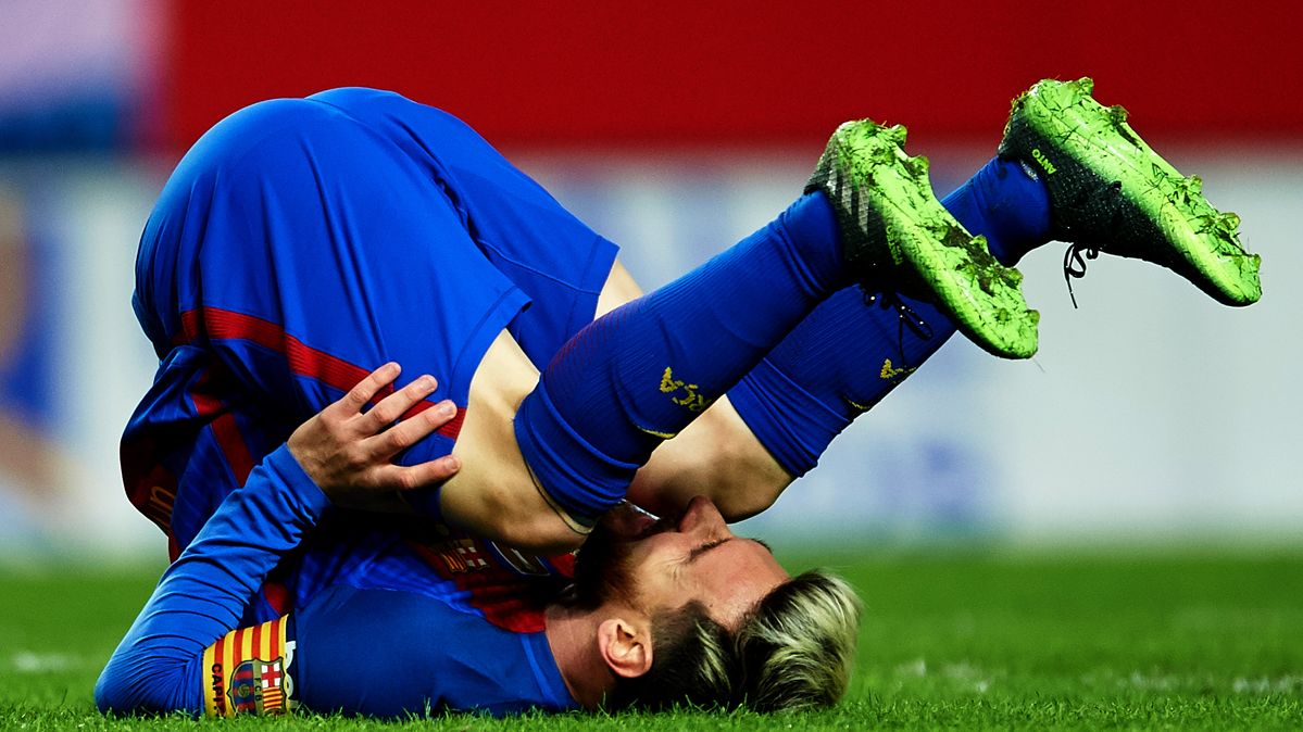 Leo Messi, derribado tras recibir una entrada de un jugador del Sevilla