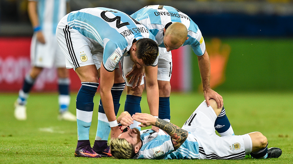 Javier Mascherano and Funes Mori check the state of Messi after a fault