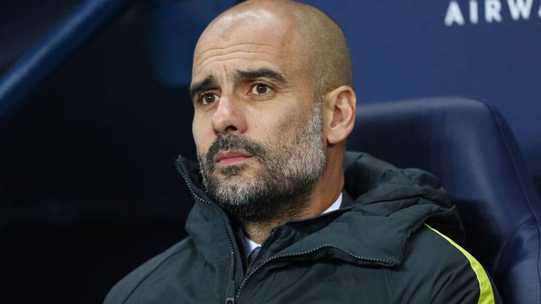 Pep Guardiola, seated in the bench of the Manchester City
