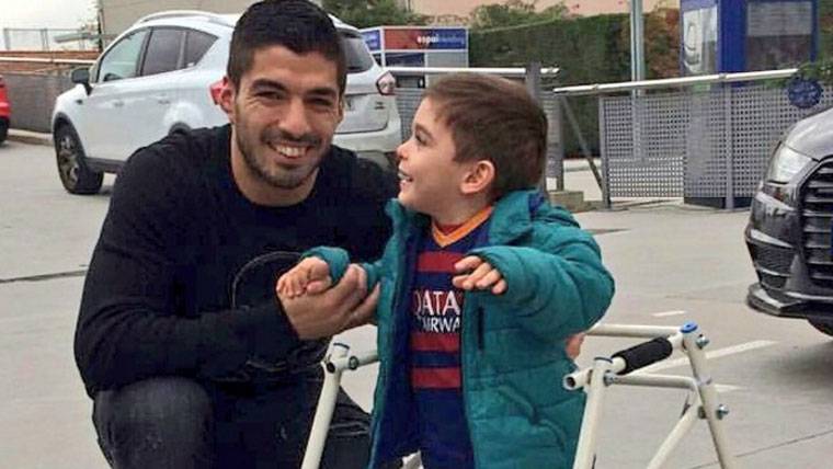 Luis Suárez, posing beside a boy with difficulties to walk
