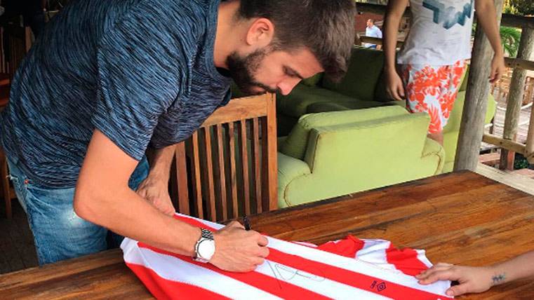 Gerard Piqué firmando un autógrafo en una camiseta del Junior de Barranquilla