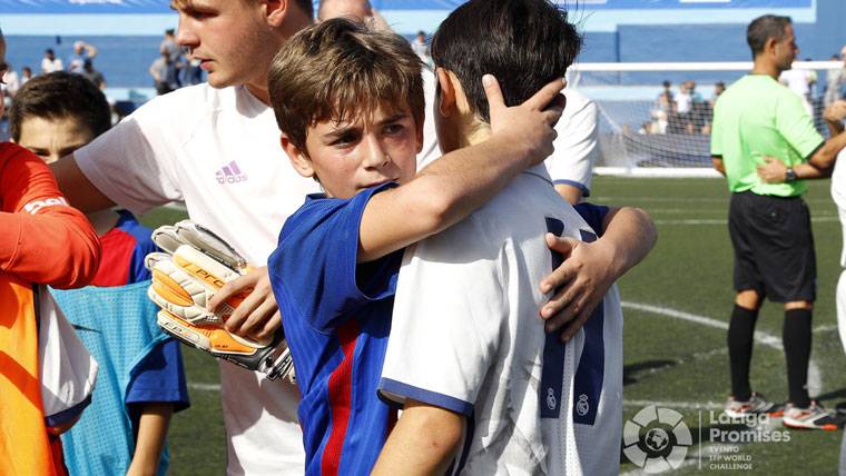 Jóvenes jugadores de FC Barcelona y Real Madrid, saludándose tras el partido