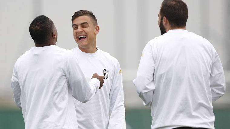 Paulo Dybala, sonriendo con sus compañeros en un entreno