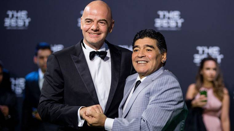 The president of the FIFA, Infantino, posing beside Maradona