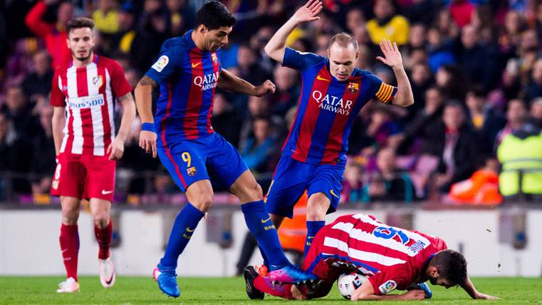 Luis Suárez y Andrés Iniesta, intentando robar un balón al Atlético