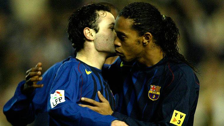 Andrés Iniesta abrazado a Ronaldinho en su tiempo como jugador del Barça