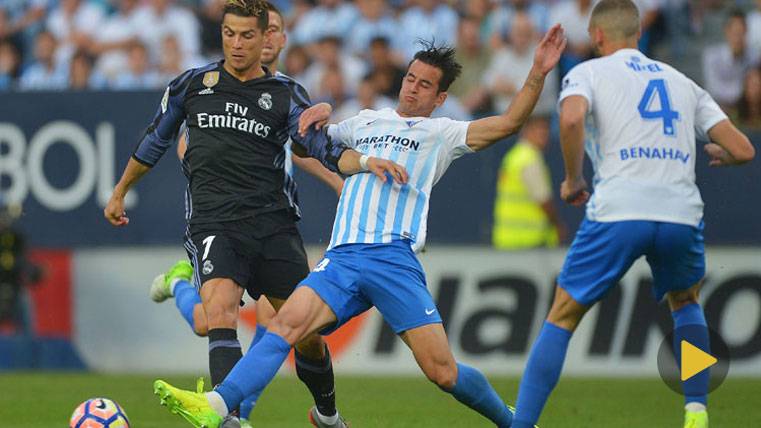 Cristiano Ronaldo, intentando marcharse de dos defensores del Málaga