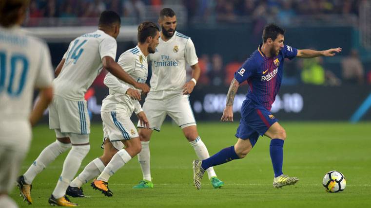 Leo Messi, surrounded of players of the Real Madrid