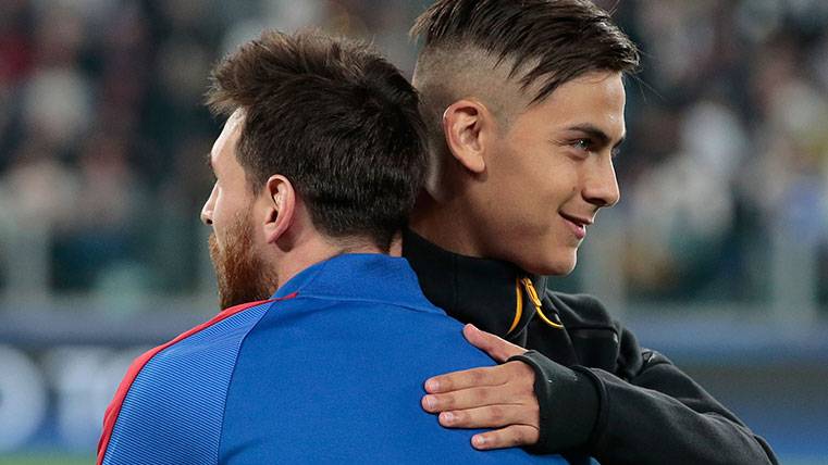 Leo Messi y Paulo Dybala se saludan durante un partido de Champions