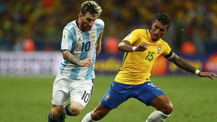 Leo Messi y Paulinho pugnan por un balón en un Brasil-Argentina