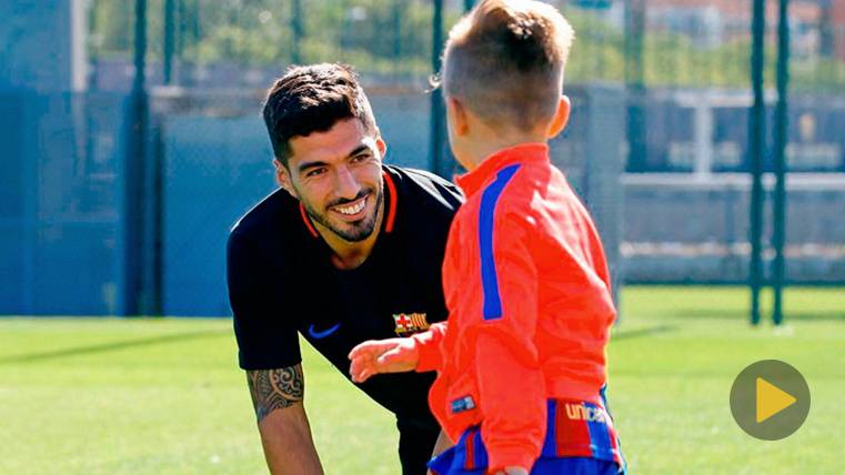 Luis Suárez beside one of his children in a training in the Sportive City