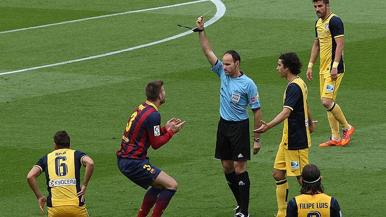Mateu Lahoz, mostrando una tarjeta amarilla a Gerard Piqué