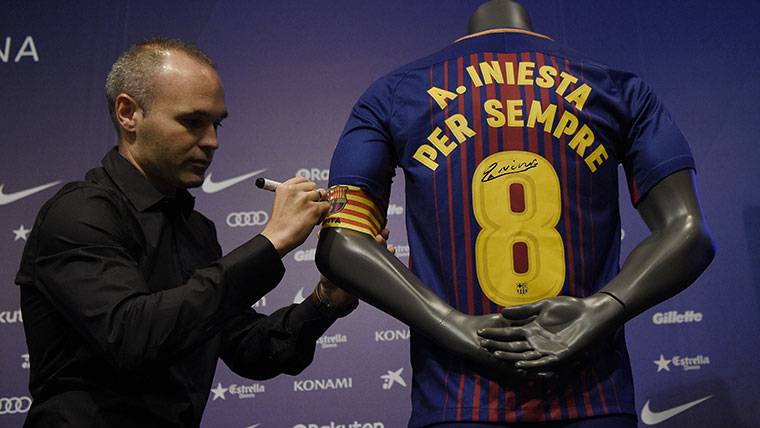 Andrés Iniesta, firmando una camiseta con su nombre