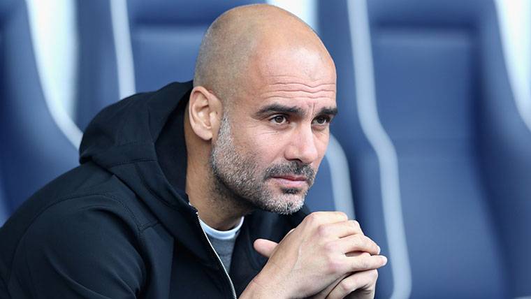 Pep Guardiola, seated in the bench of the Manchester City