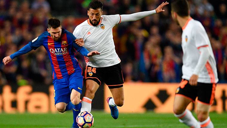 Leo Messi pugna con Ezequiel Garay en un partido en el Camp Nou