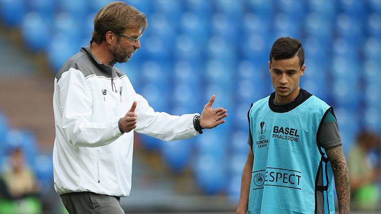 Philippe Coutinho attends to the explanations of Jürgen Klopp