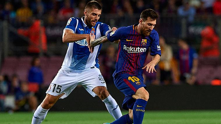 Leo Messi y David López pugnan por un balón
