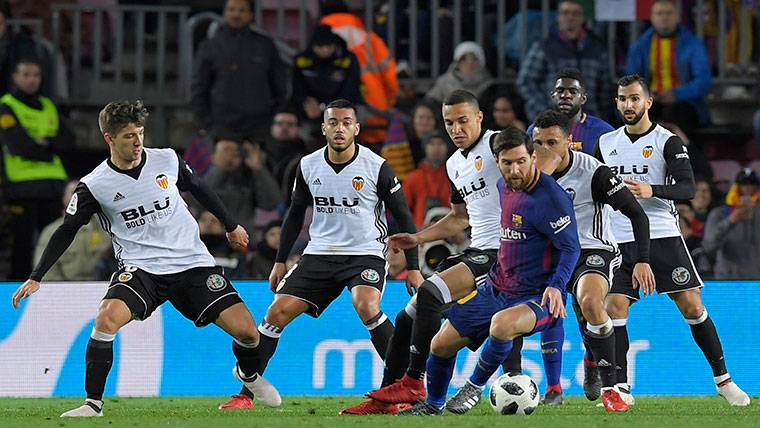 Messi, acumulando a hasta cinco jugadores contra el Valencia