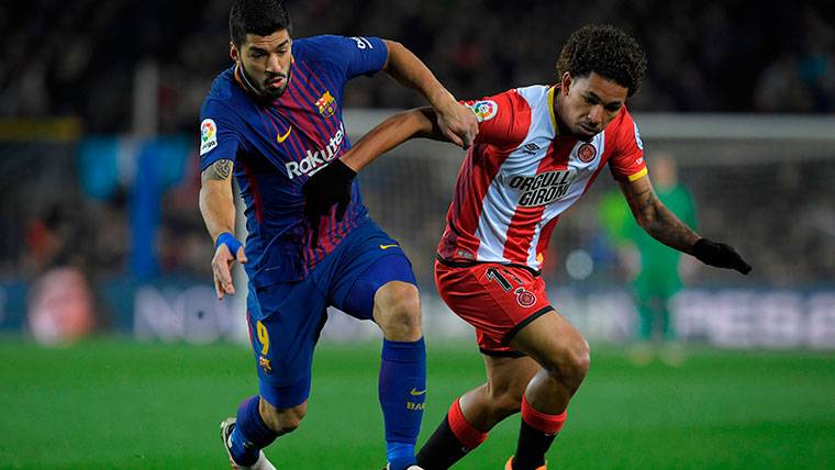 Luis Suárez, luchando por un balón con un defensor del Girona