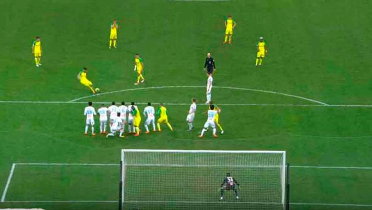 Un jugador del Olympique de Marsella, agachado tras la barrera