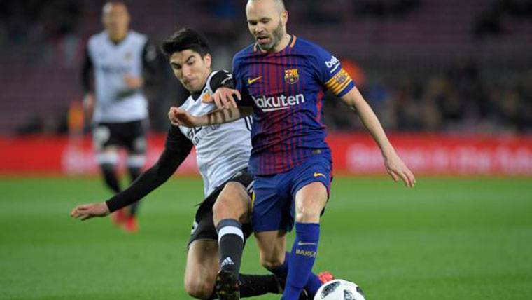 Carlos Soler, intentando arrebatar un balón a Andrés Iniesta