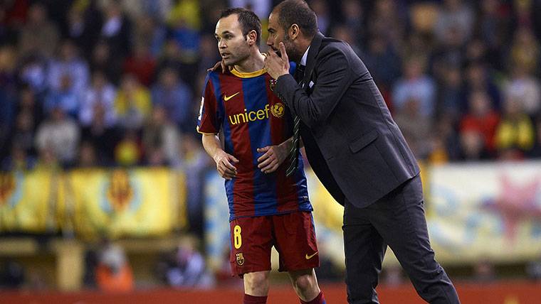 Pep Guardiola and Andrés Iniesta, conversing in an image of archive