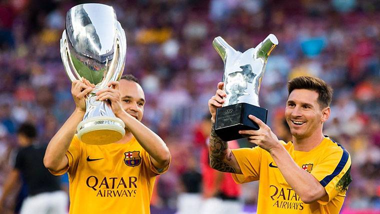 Leo Messi and Andrés Iniesta, raising trophies with the FC Barcelona