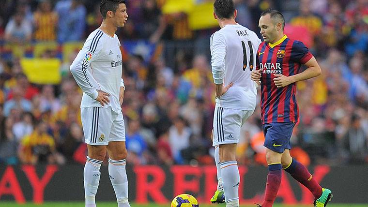 Andrés Iniesta, pasando entre Cristiano Ronaldo y Gareth Bale
