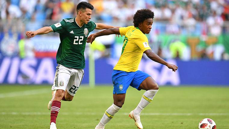 Hirving Lozano y Willian pugnan por un balón en el Mundial