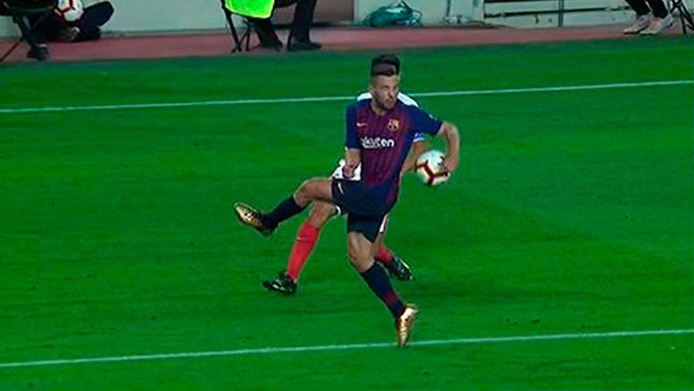 Jordi Alba, desviando un balón con el brazo extendido en el área del Barça