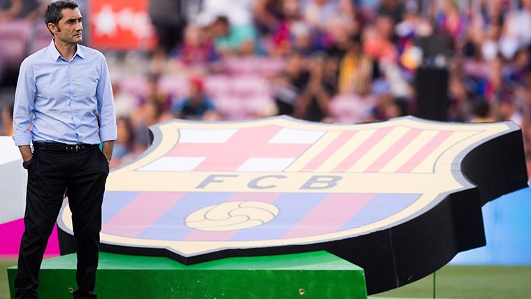 Ernesto Valverde poses beside the shield of the FC Barcelona
