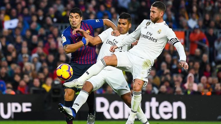 Luis Suárez y Sergio Ramos, luchando por un balón en un Clásico