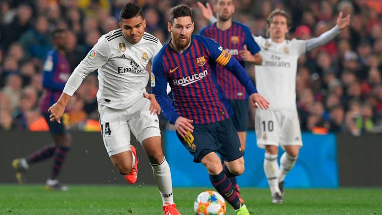 Messi drives a balloon in front of Casemiro in a Barça-Madrid