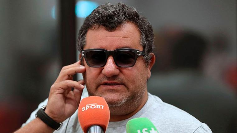Mino Raiola hablando por teléfono frente a unos micrófonos