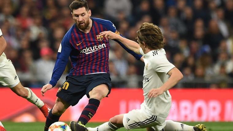 Modric, al suelo para intentar arrebatar un balón a Leo Messi