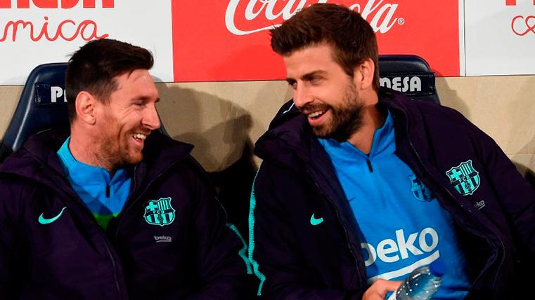 Piqué y Messi bromean en el banquillo